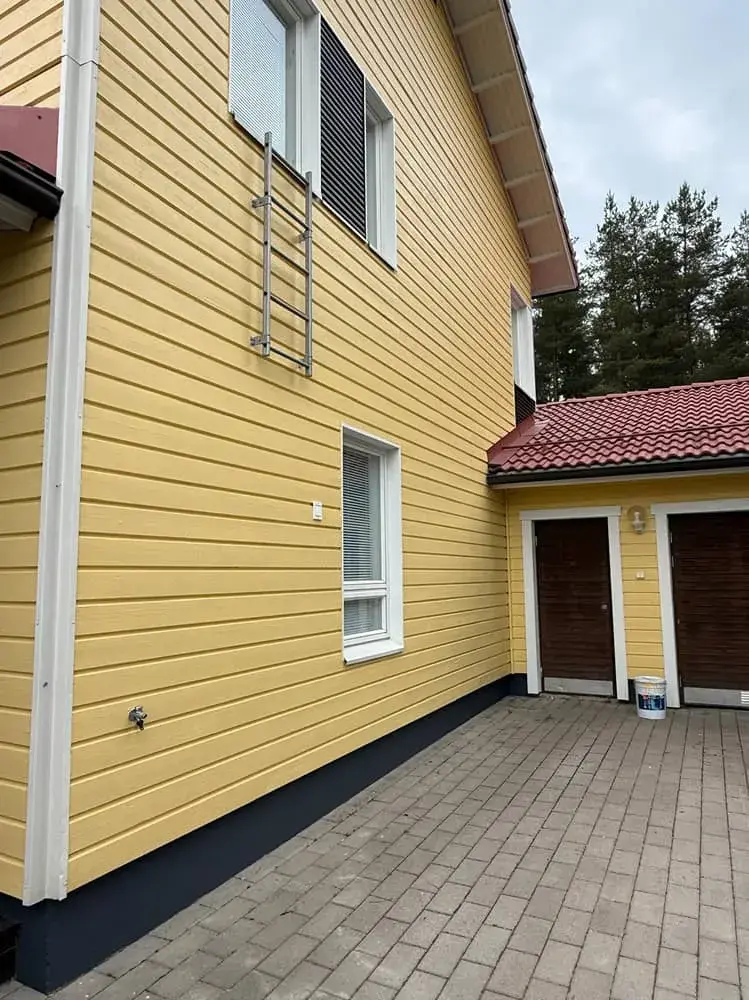 Maalattu tumma sokkeli keltaisessa puutalossa – Maalauskulma